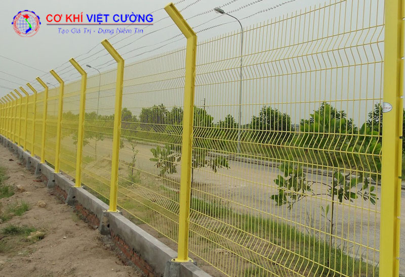 Hàng rào lưới thép cột trái đào sơn màu vàng.